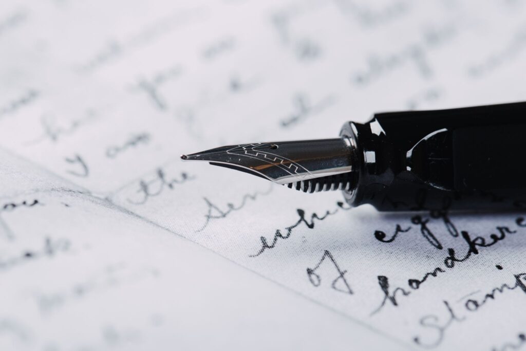 An elegant fountain pen resting on an open notebook page for therapeutic journaling.